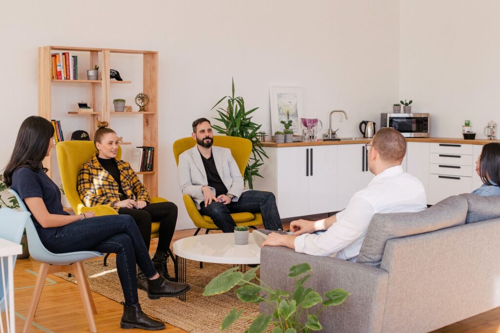 group of people sitting on a couch and lounge chairs in a casual office environment. Executive Recruitment Firm - Kitchener Executive Consultants